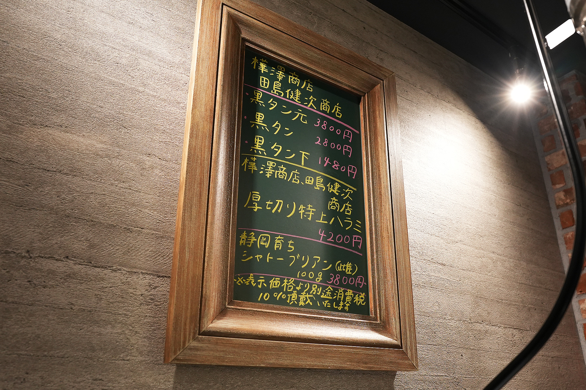 麻布苑の黒板メニュー。樺澤商店・田島健次商店といった仕入れ先の名前と、黒タン元3800円などの価格が書かれている