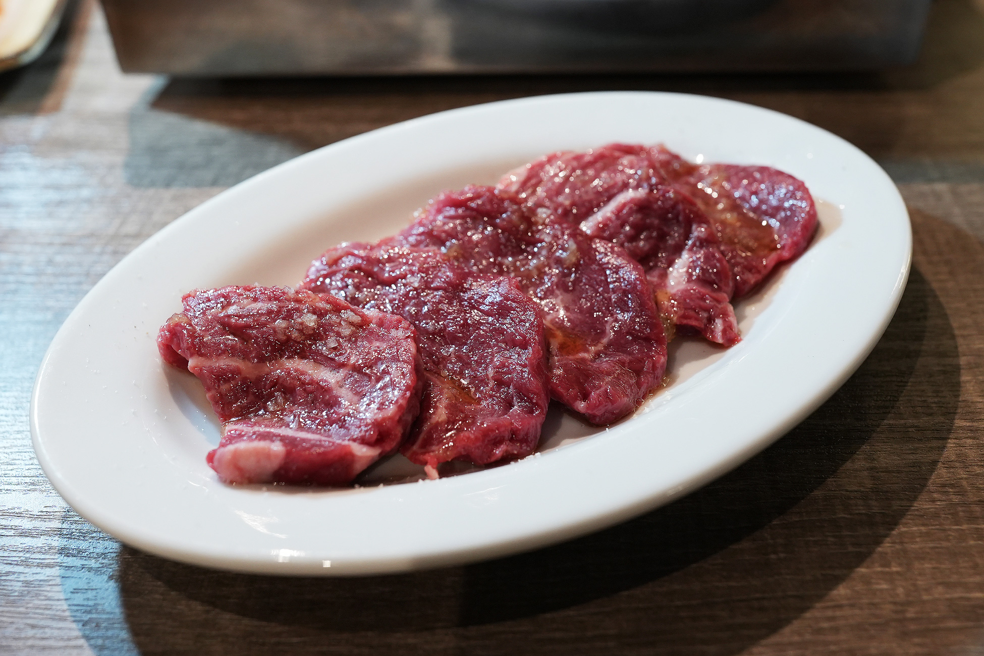 麻布苑の赤身ヒレ。薄めにスライスされた赤身に粗塩がのり、にんにく醤油のタレが敷かれている