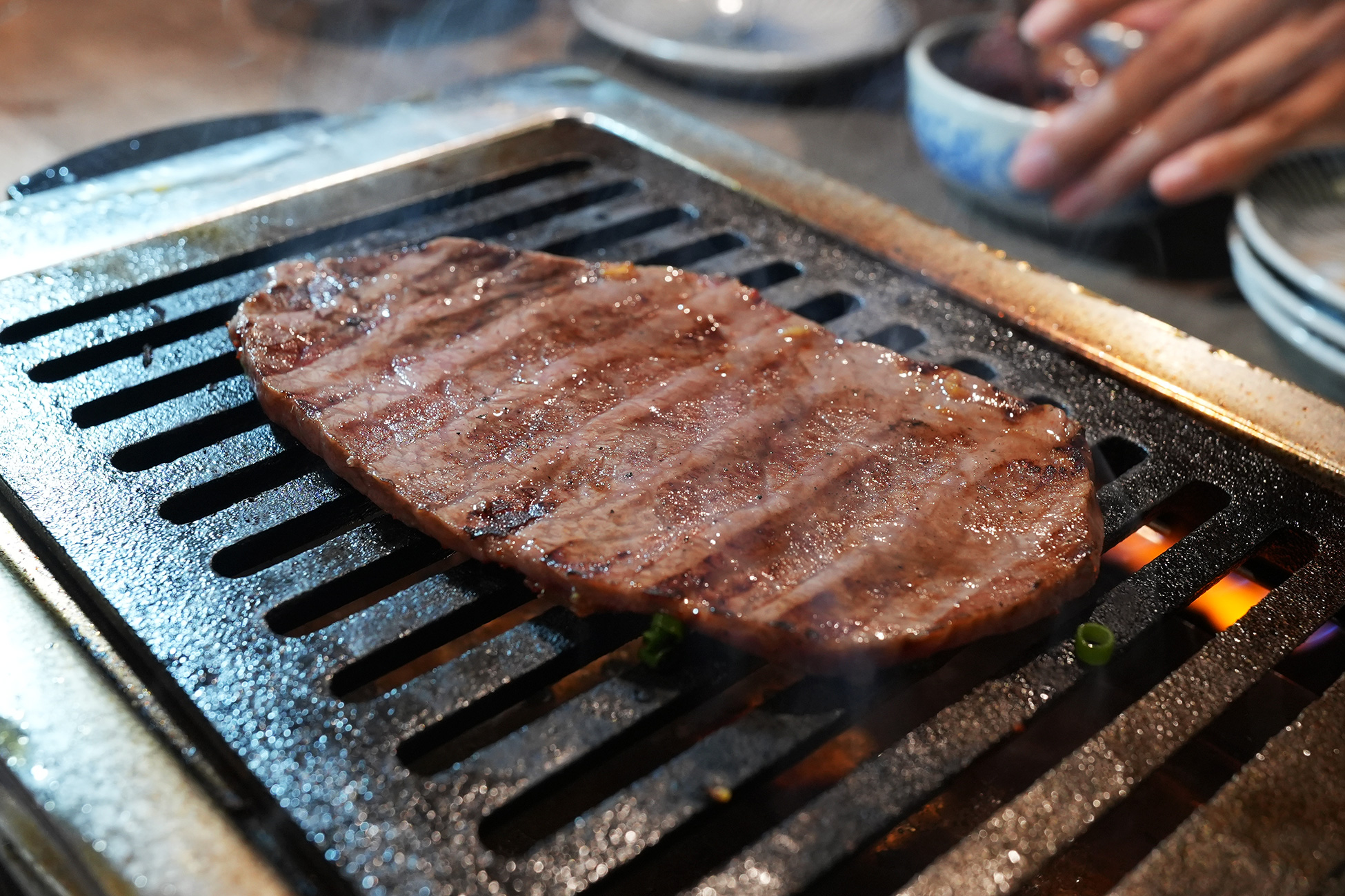 麻布苑のシンシンを焼いているところ。網の上で大判の肉が焼かれている