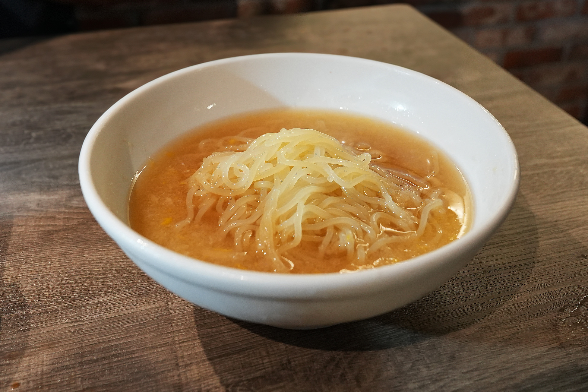 麻布苑の麻布冷麺。透明感のあるスープに細麺が盛られ、大根おろしがのっている