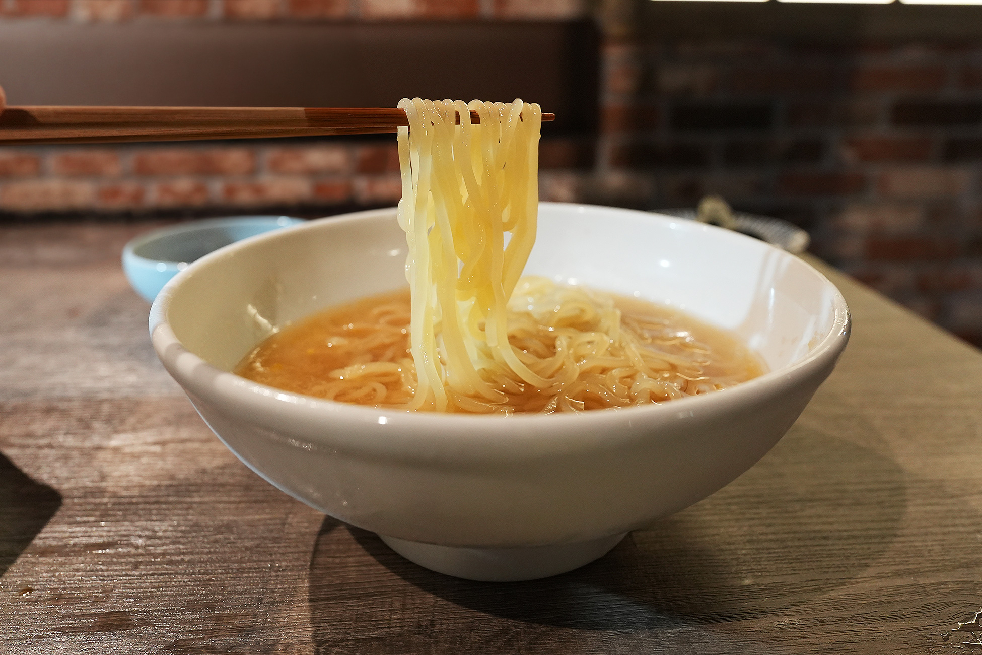 麻布苑の麻布冷麺の麺を箸で持ち上げたところ。細くコシのある麺が見える
