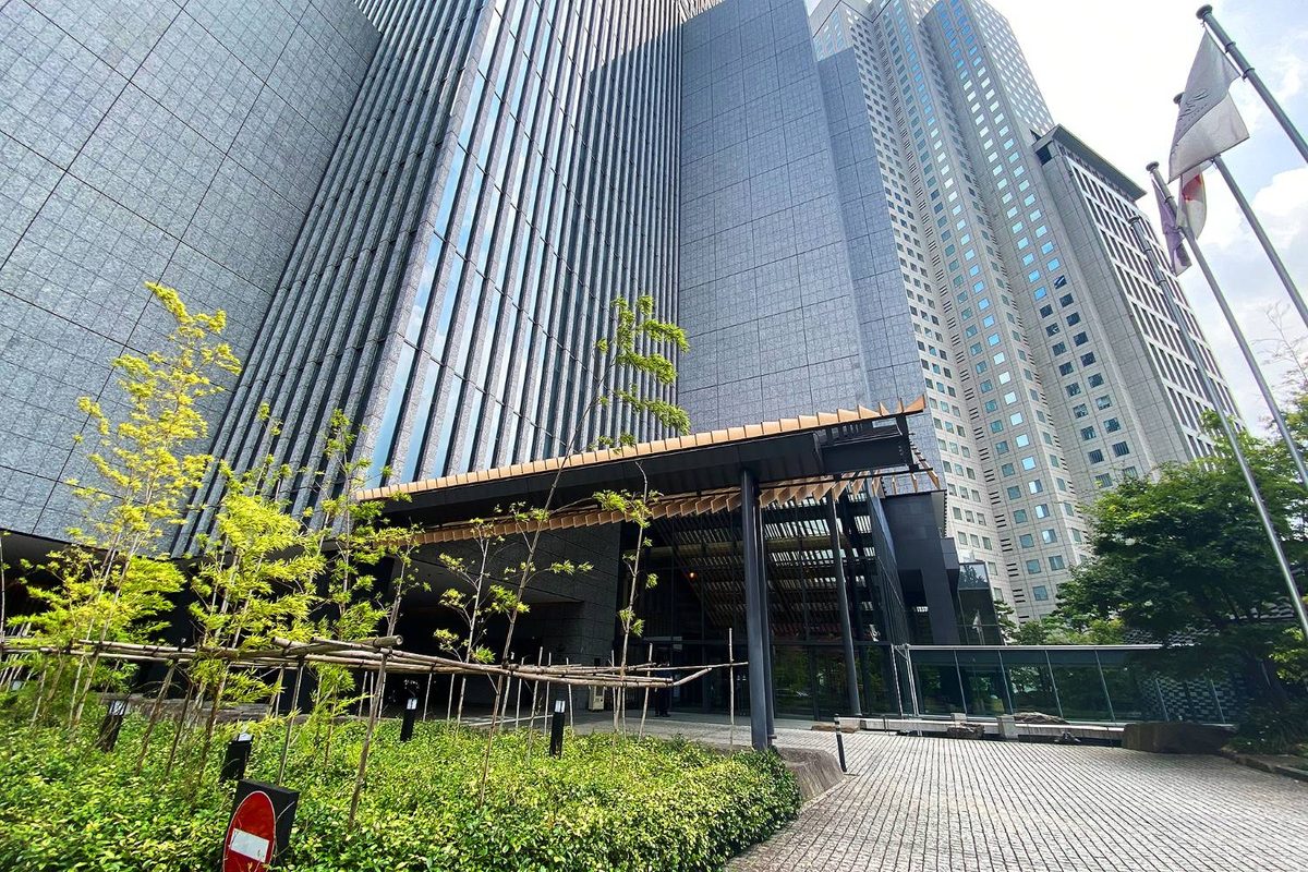 ザ・キャピトルホテル 東急の外観。高層タワーの足元に木を組んだ大きなひさしがかかり、手前には竹垣と植栽がある