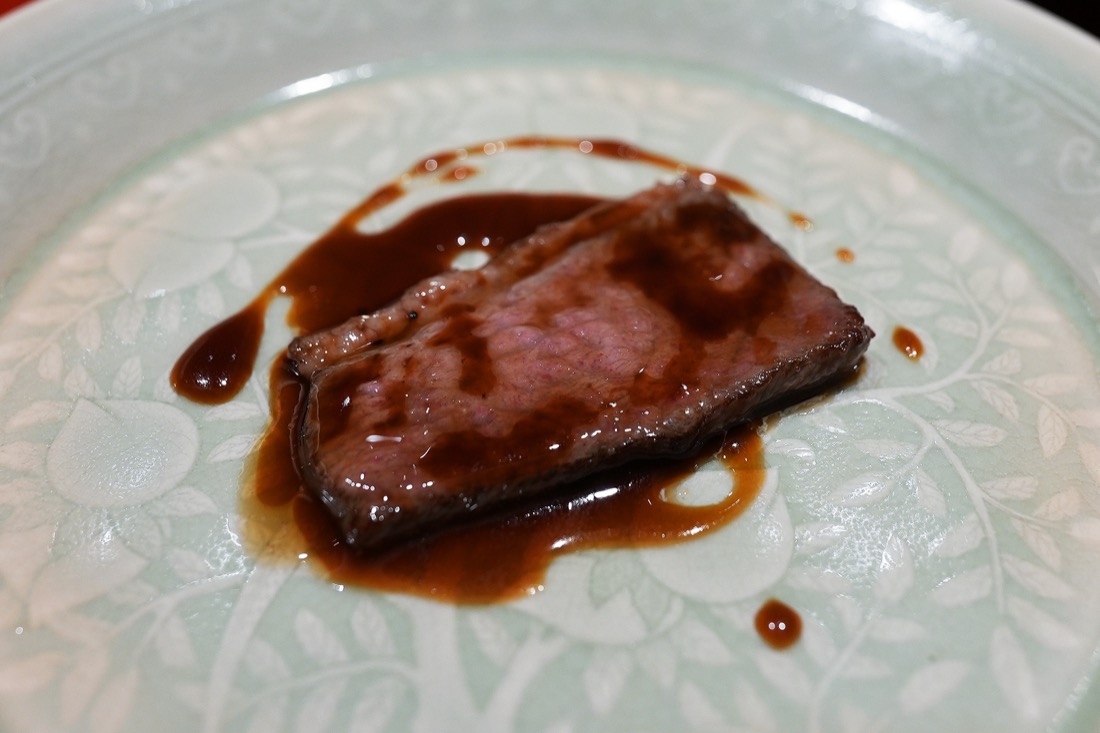 青磁の皿にのせた鴨肉に、艶のある赤ワインソースをかけた一皿
