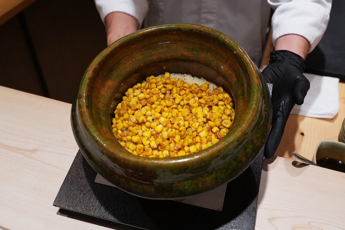 緑釉の土鍋いっぱいに広がる、炊き上がったとうもろこしご飯