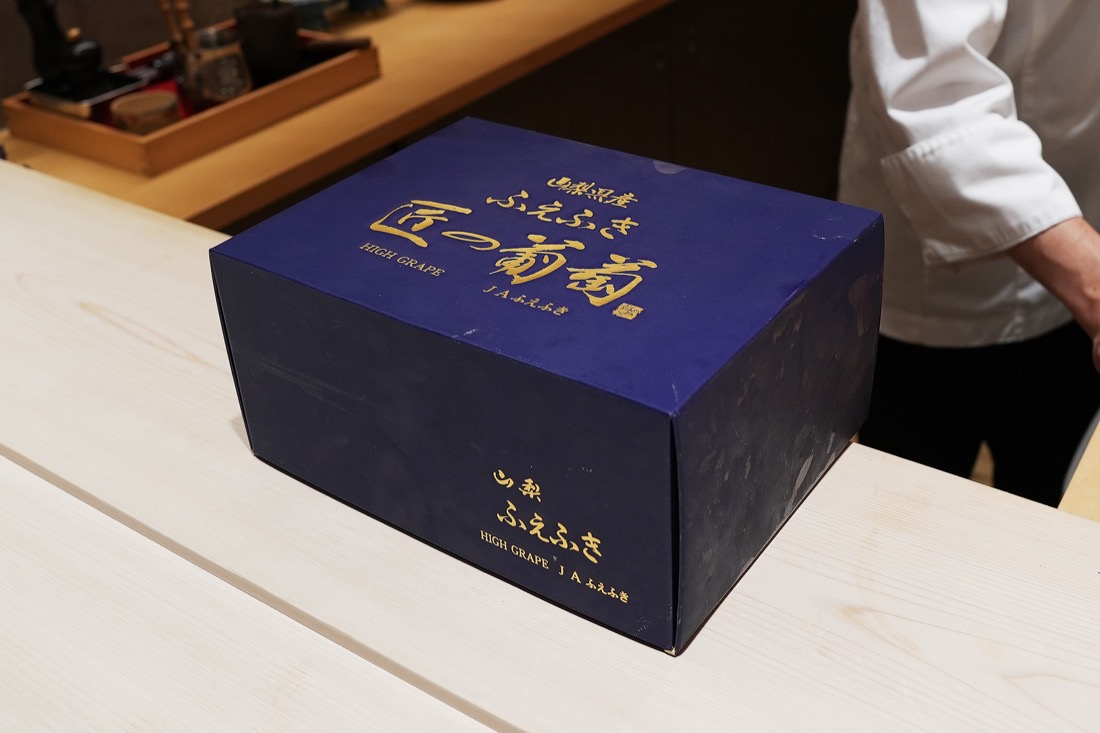 カウンターに置かれた、山梨県産シャインマスカット「匠一房」の紺色の化粧箱