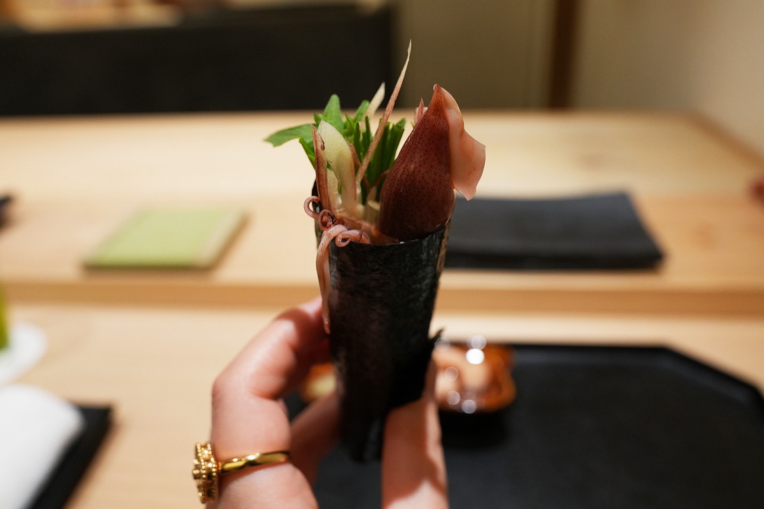 海苔で巻いた蛍烏賊の手巻きを手に持ったところ