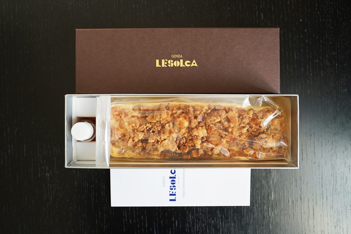 箱を開けたところ。袋に入ったチーズケーキと、はちみつの小瓶、ショップカードが入っている