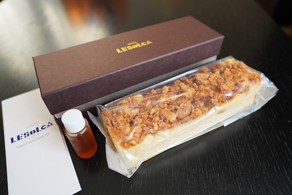 チーズケーキ本体と、栗のはちみつの小瓶、箱、ショップカードを並べたところ