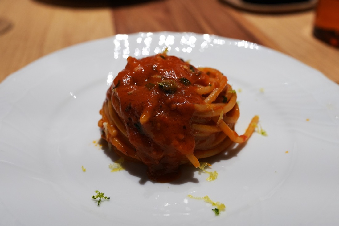 白い皿に巻いて盛られた、トマトソースのスパゲッティ