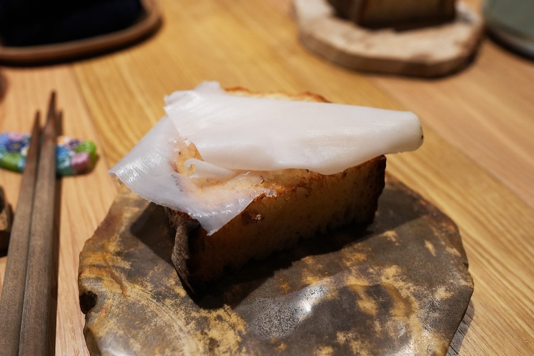 焼いたライ麦パンに、透きとおるほど薄く削ったラルドを一枚のせた一品