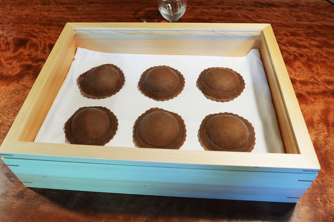 木の箱に並べられた、焼く前のどんぐり粉のラビオリ6つ