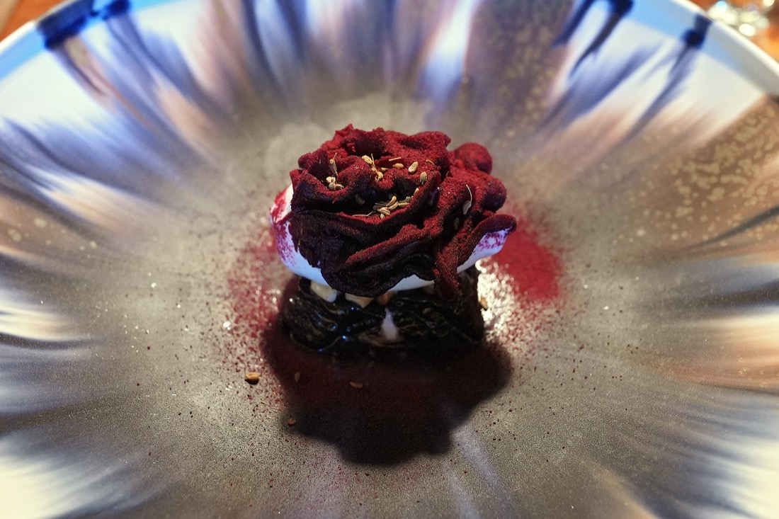 青と白の器に、薔薇のような形に仕立てた濃い赤色のビーツと白いアイスを盛った一皿