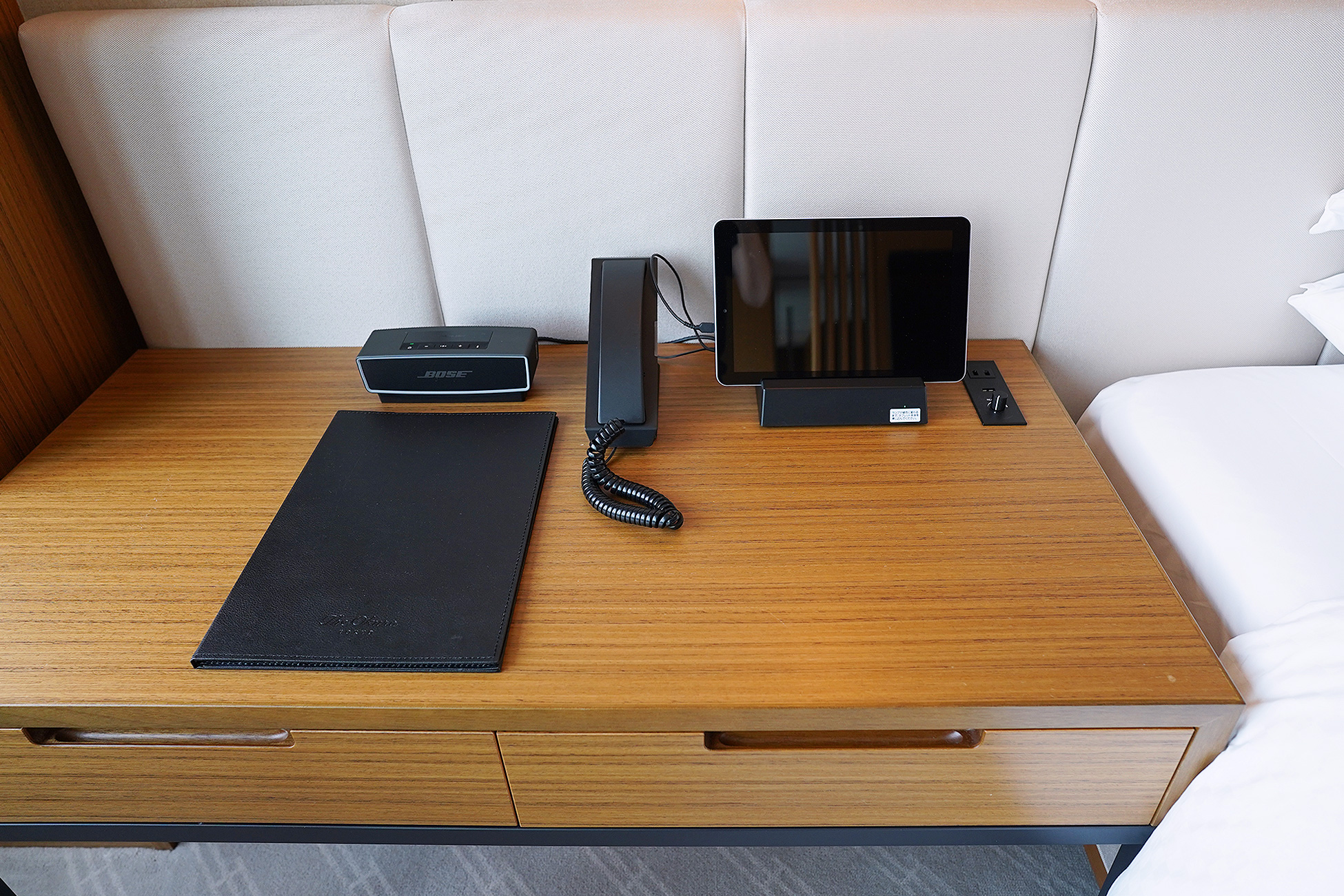 The Okura Tokyoプレステージルームのデスク。レザーのマットの上にタブレットと電話が置かれている