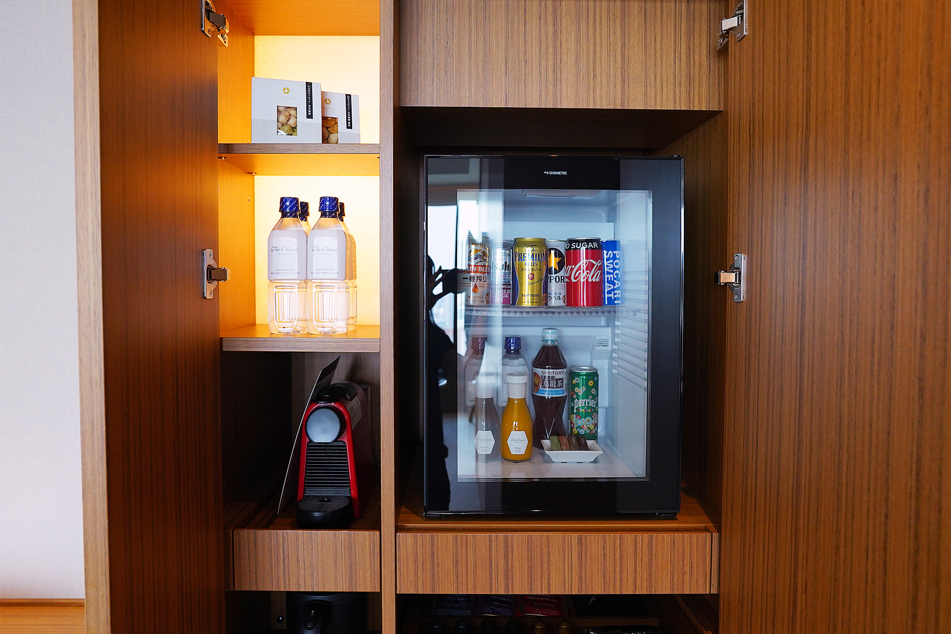 The Okura Tokyoプレステージルームのミニバー。木の棚に冷蔵庫が組み込まれ、飲み物が並んでいる