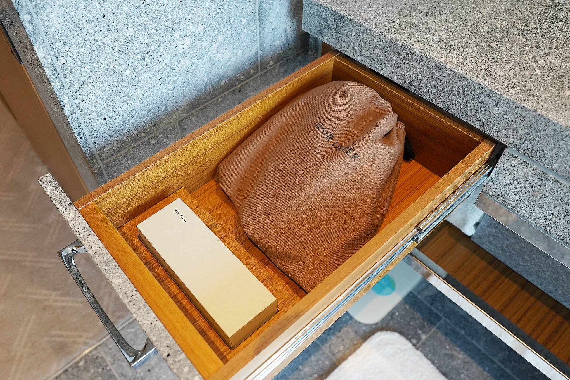 The Okura Tokyoプレステージルームの洗面台下の引き出し。ヘアドライヤーの布袋とヘアブラシの箱が収められている