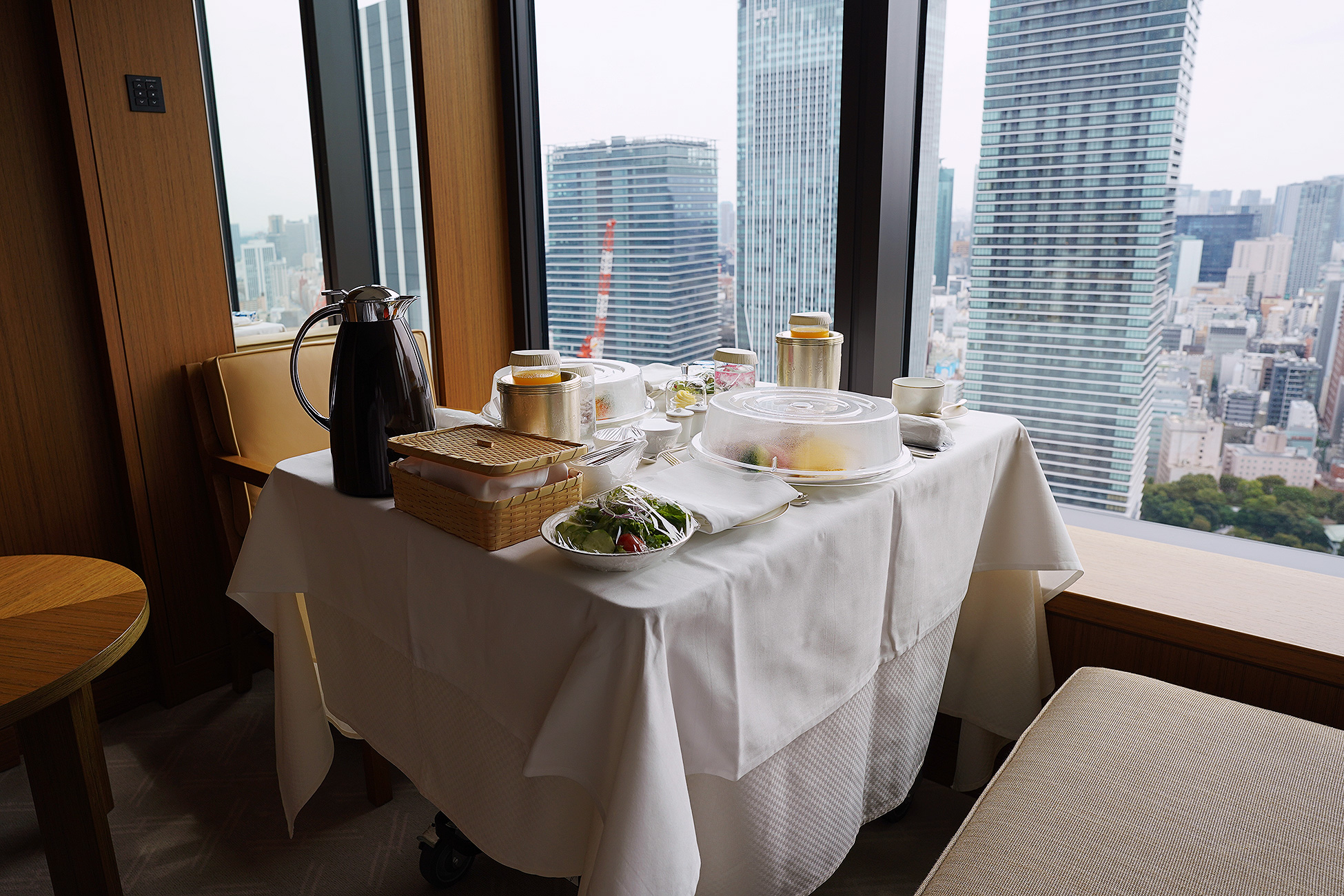 The Okura Tokyoのルームサービス朝食のセッティング。窓際の丸テーブルに白いクロスが掛けられている