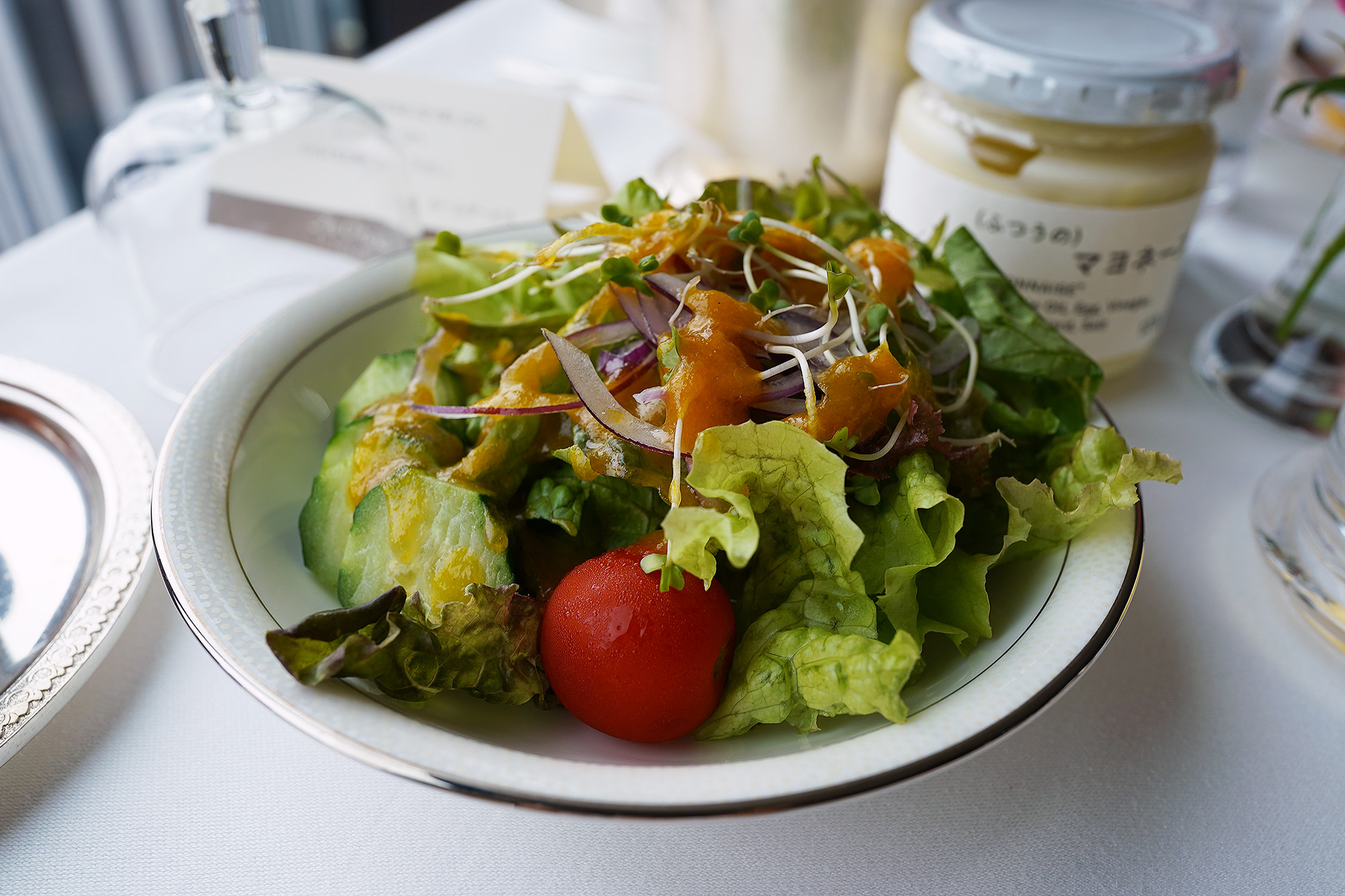 The Okura Tokyoのルームサービス朝食のサラダ。葉物と胡瓜、トマトが白い器に盛られている