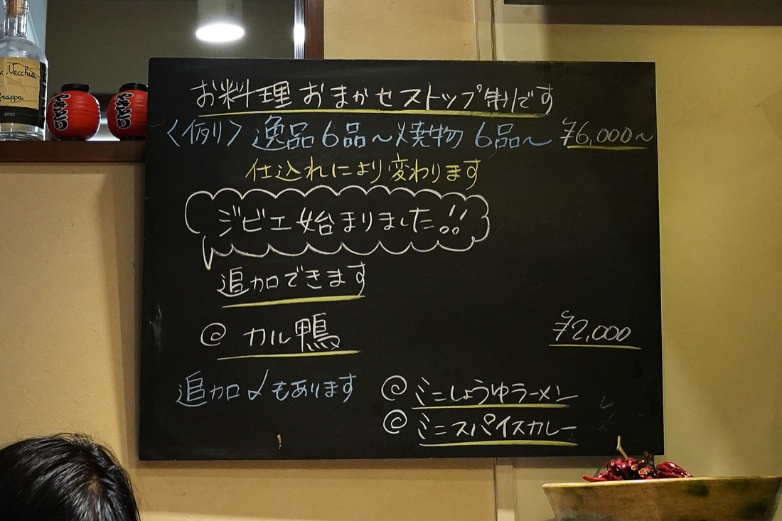 店内の黒板。おまかせストップ制、逸品6品〜焼物6品〜6,000円〜、ジビエ始まりました、追加できます、と書かれている