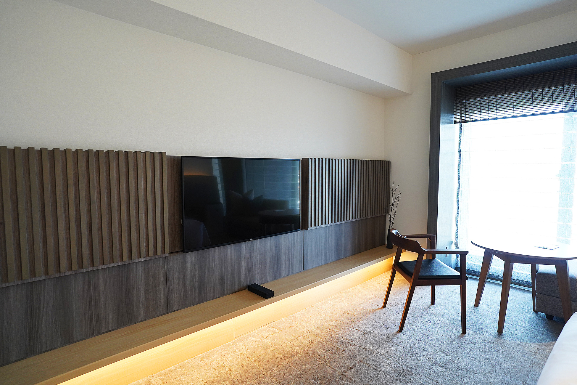 THE THOUSAND KYOTOの客室のテレビ壁。縦格子の壁が横に長く伸び、下部に間接照明が入っている
