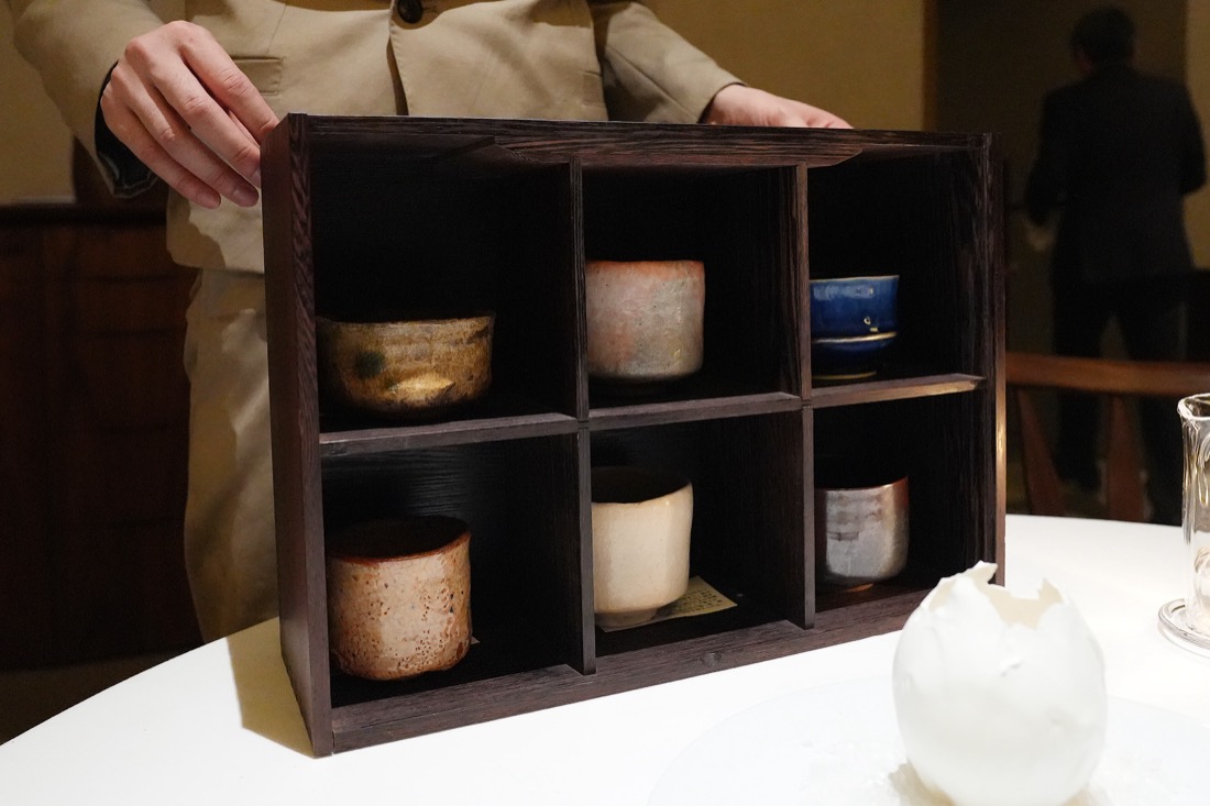 木の箱に6つの茶碗が並べられ、その中から選ぶところ