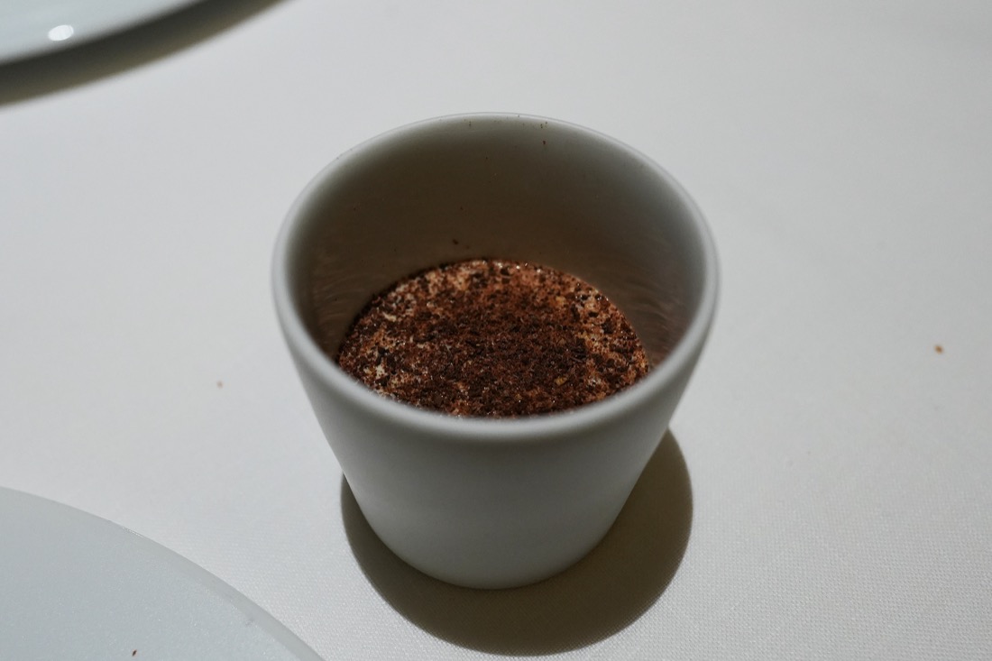白い器に盛られ、表面に茶色い粉をふった一品