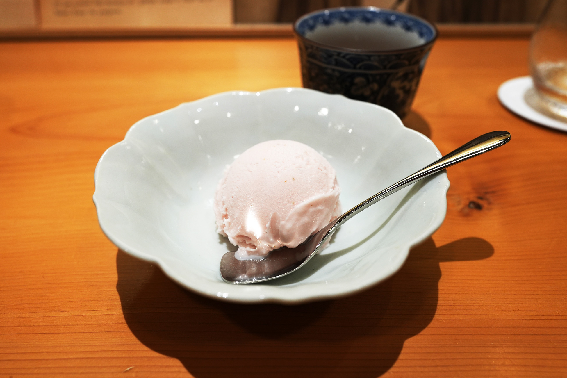 白い花形の器に盛られた、淡いピンク色のアイスクリーム