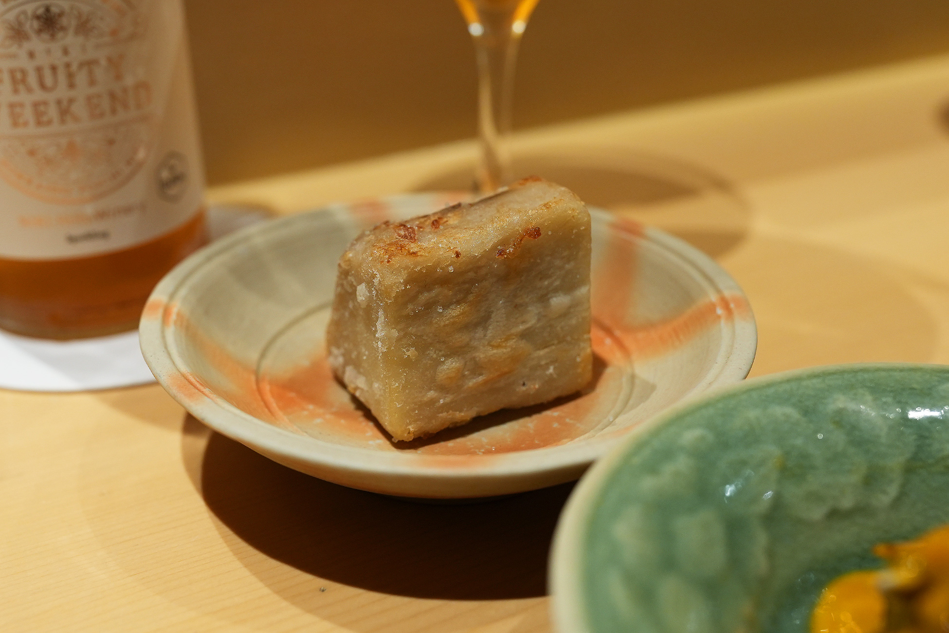 色絵の小皿にのせた四角い海老芋の唐揚げ。表面に焼き色がつき、断面には層になった繊維が見える