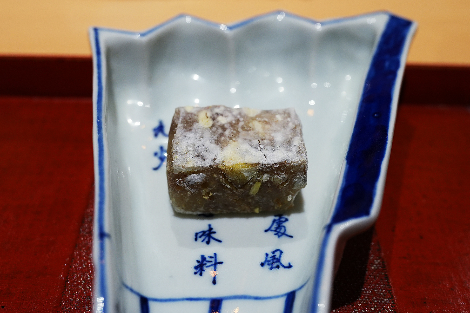 染付の器にのせた四角い栗の葛焼き。表面に焼き色がついている