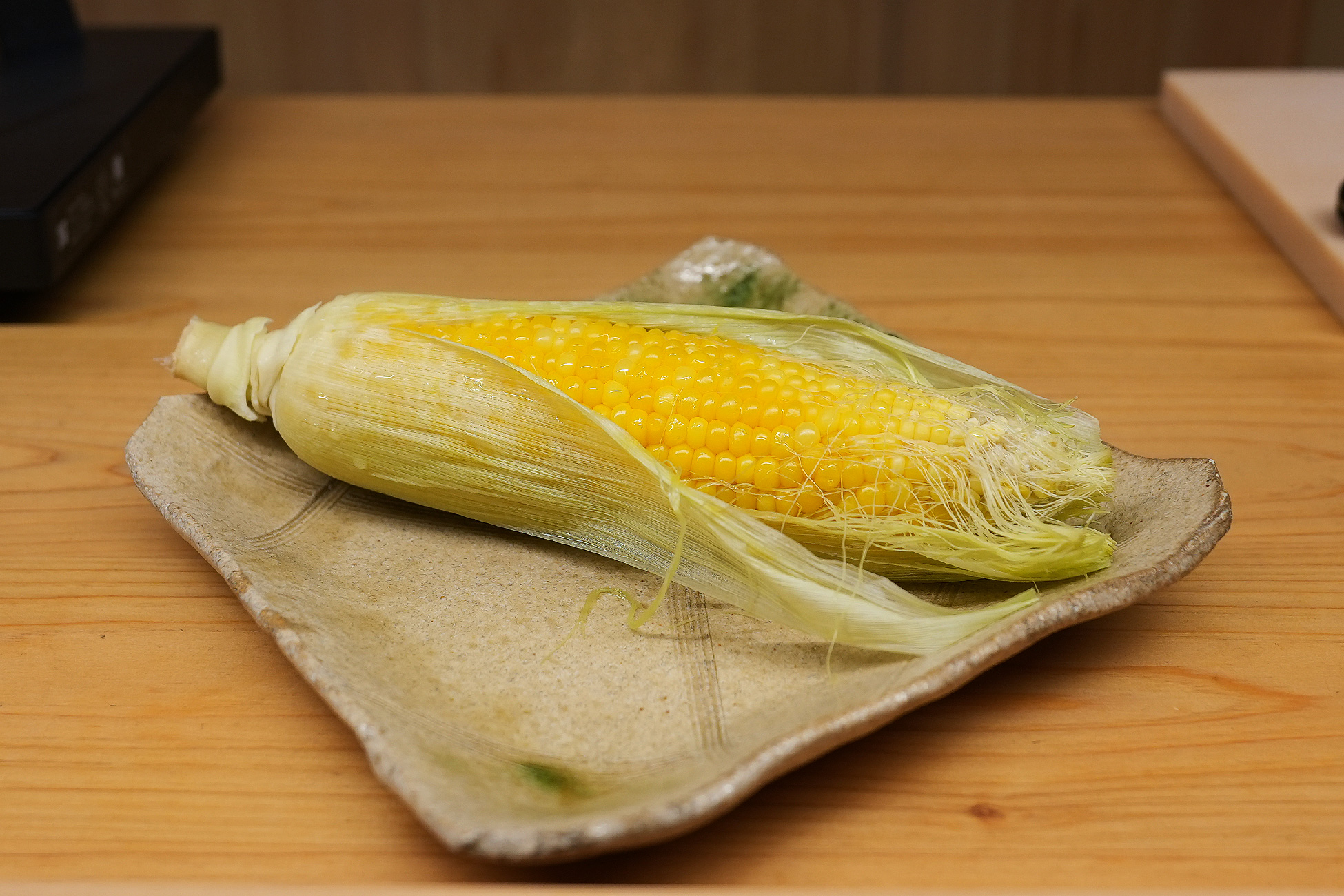 皮をむきかけた朝採れのとうもろこし。粒が黄色く詰まっている