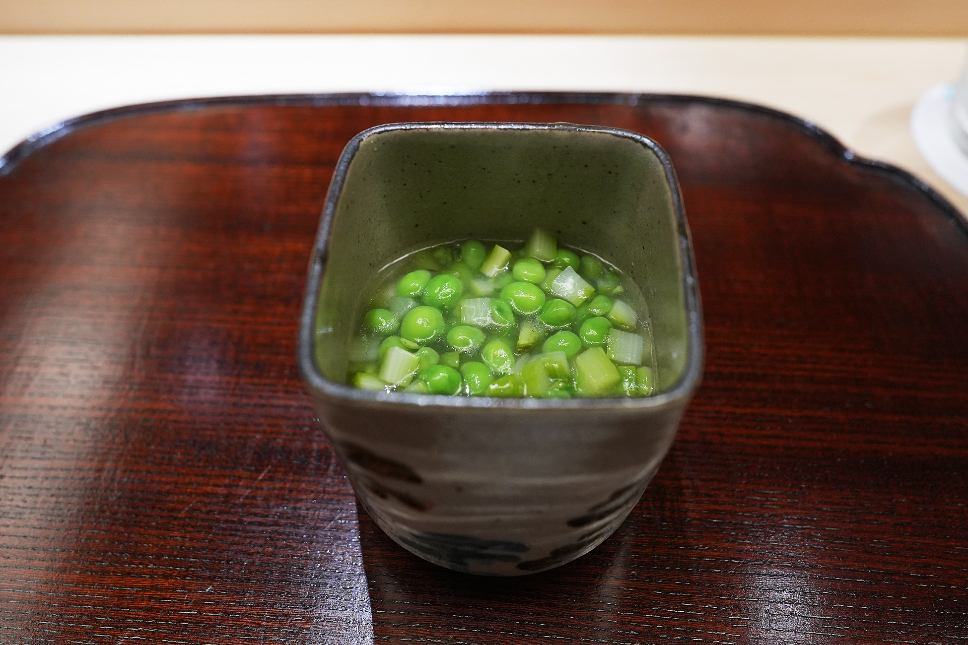 角の器に、緑の豆とアスパラガスを散らした出汁餡がかかった茶碗蒸し