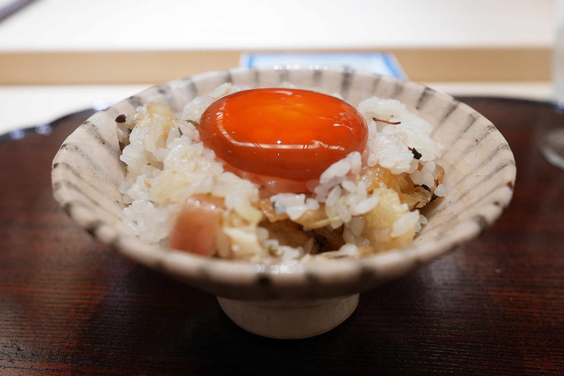 よそった土鍋ご飯の上に、半日漬けた濃い橙色の卵黄をのせたところ