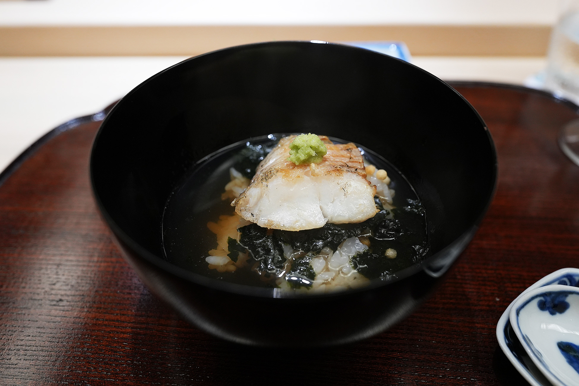 黒い椀に、焼いた白甘鯛と海苔をのせたお茶漬け
