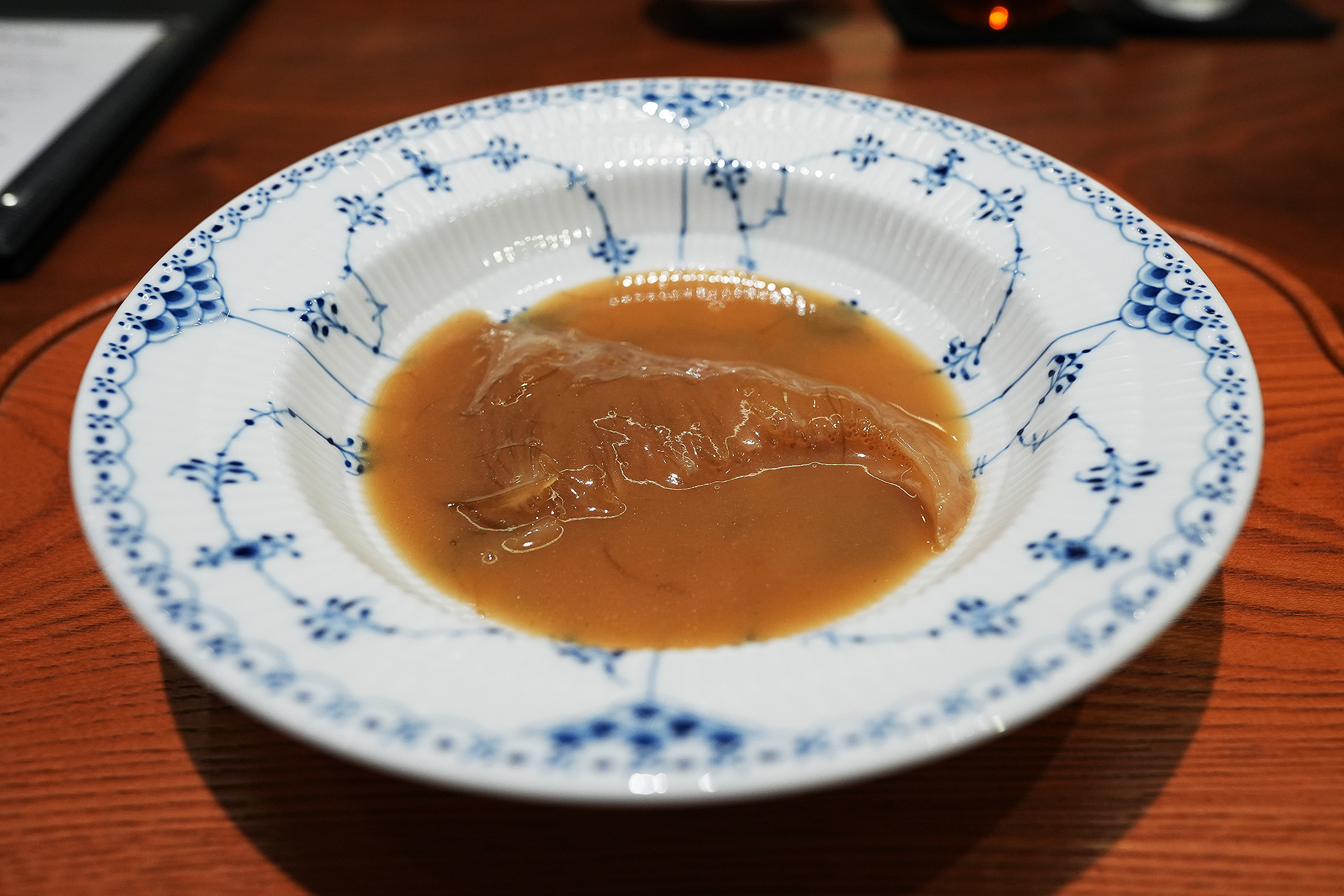 染付の深皿に、琥珀色の煮込みスープに浸かったヨシキリザメの鱶鰭。繊維が透けて見える