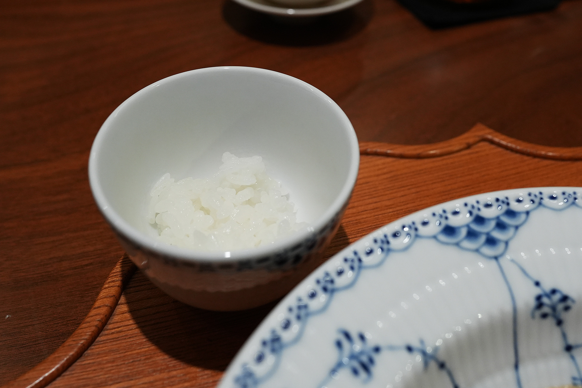 小さな茶碗によそわれた白いご飯。粒が大きくつやがある