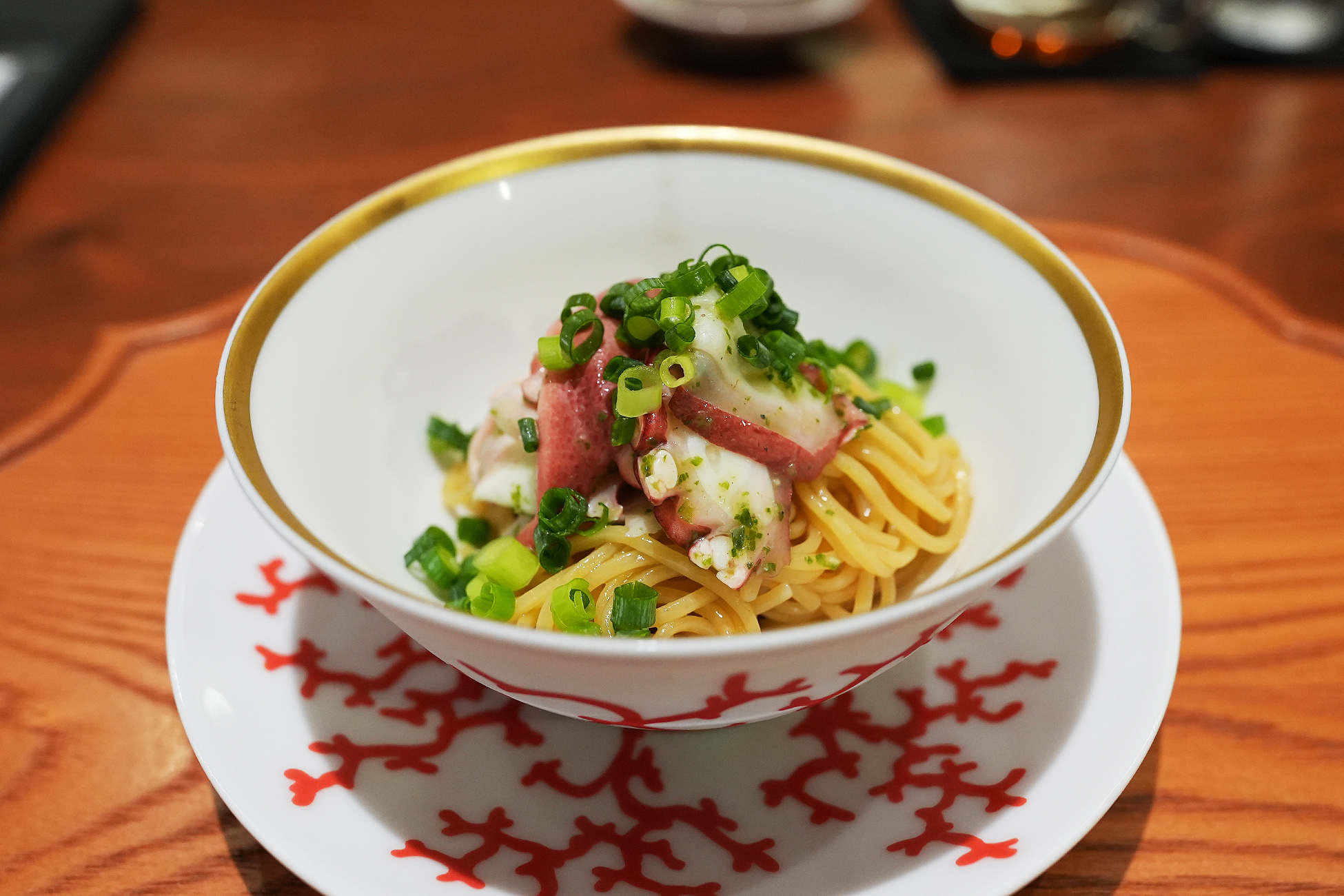 金縁の鉢に盛られた細い冷やし麺。薄切りの蛸と刻んだ青葱がたっぷりのっている