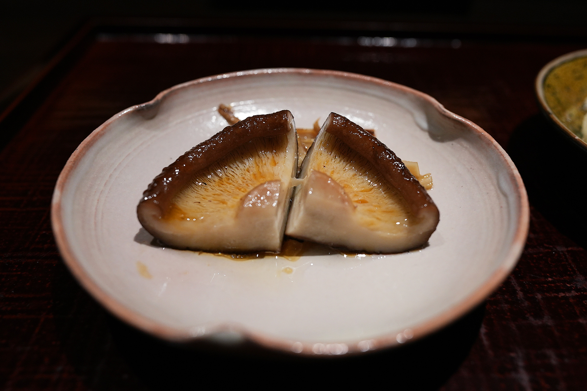 淡い色の皿に、半分に切った肉厚の椎茸が2つ。傘の表面に焼き色がつき、皿に汁が落ちている