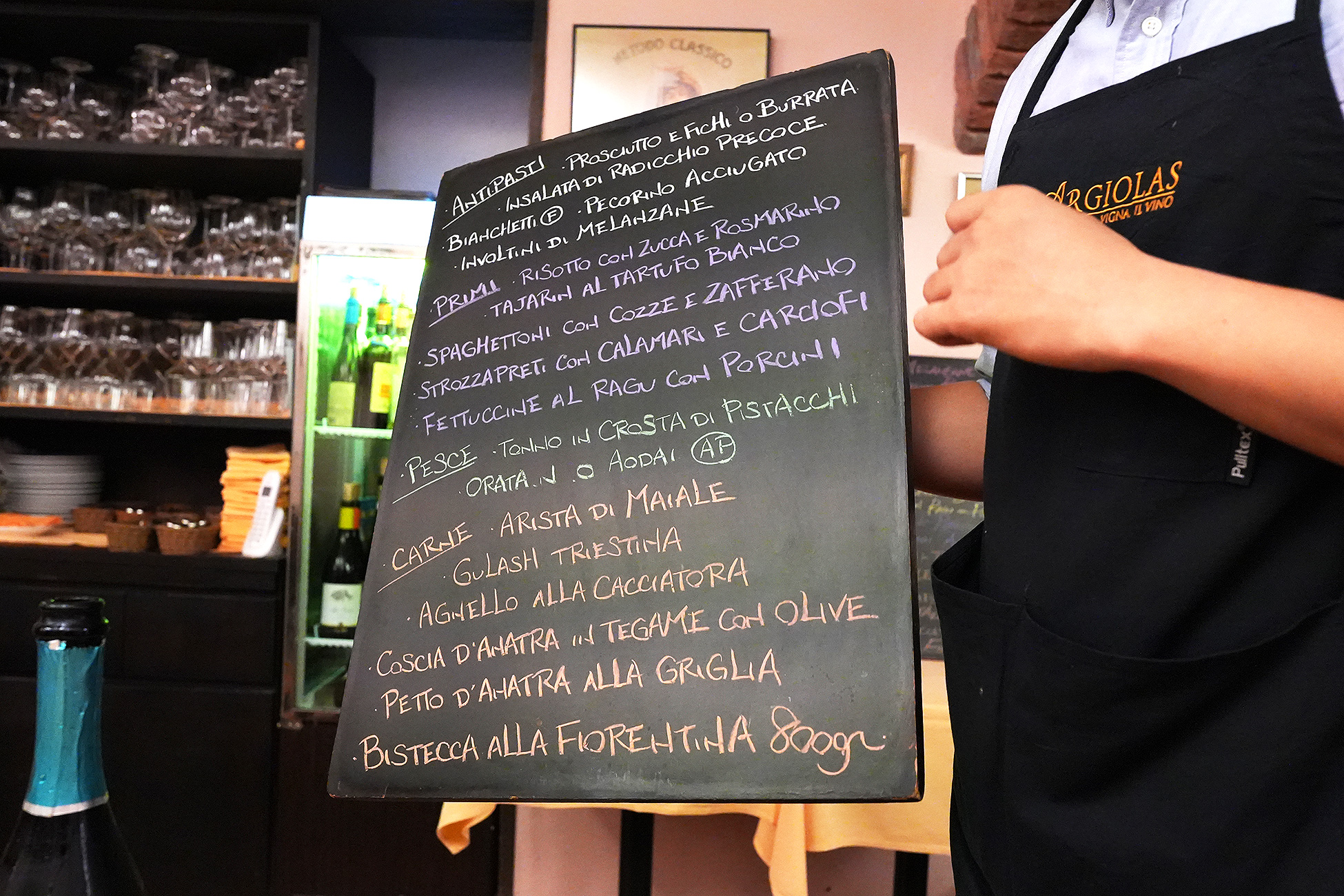 スタッフがテーブルまで運んできた、イタリア語で手書きされた大きな黒板メニュー