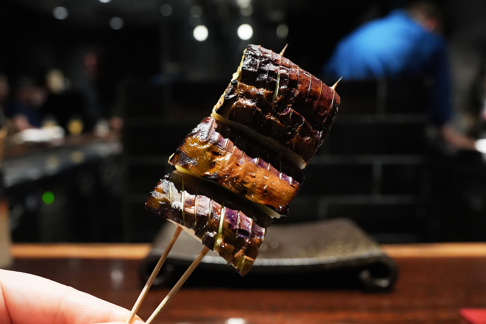 串に刺さった輪切りの茄子。紫の皮に格子状の焼き目がつき、果肉がやわらかく見える