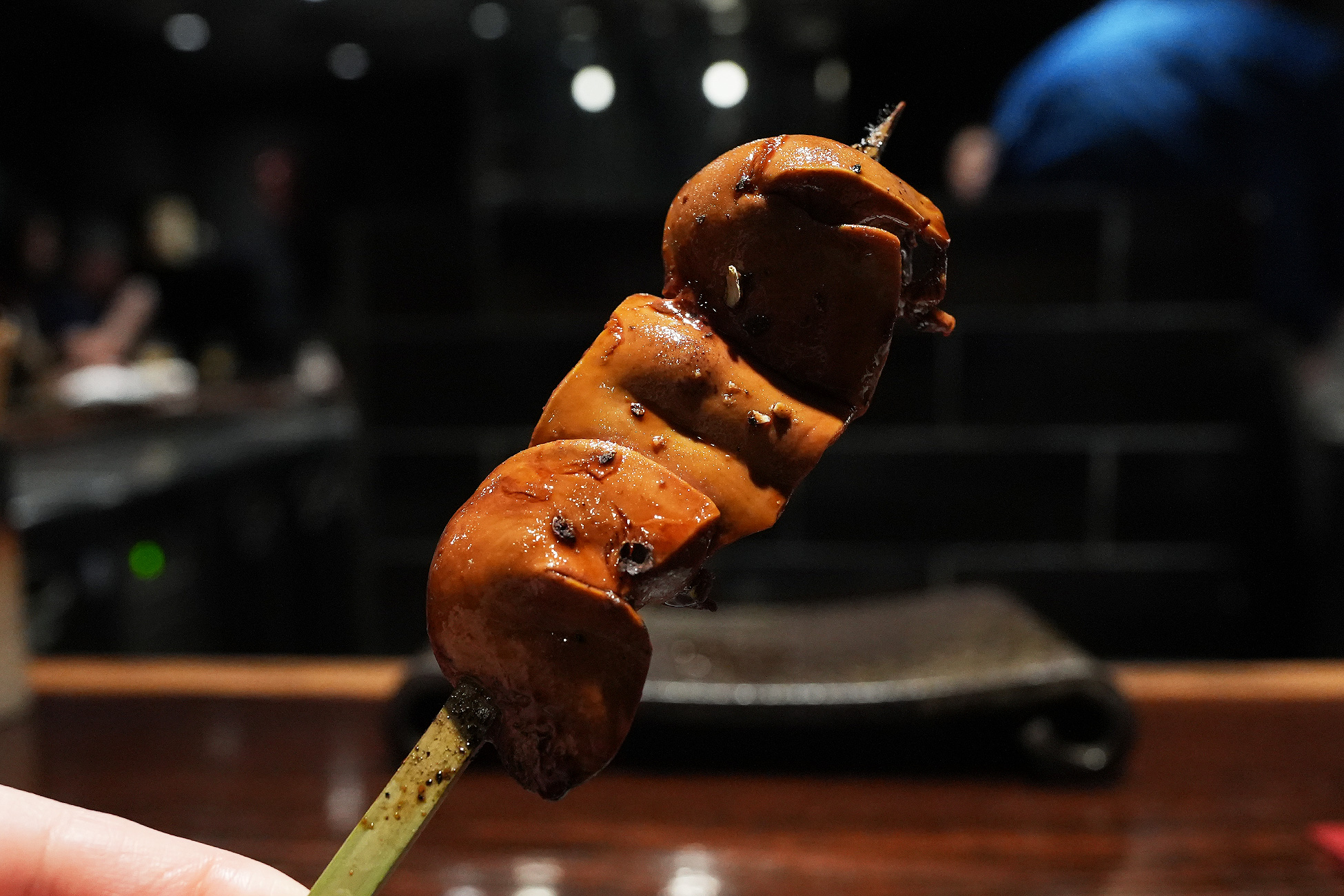 串に刺さったレバー。つやのある茶色に焼き上がり、黒い粒の山椒が振られている
